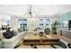 A spacious living room is lit by windows and a modern fan and light fixture at 5550 Sabal Dr, St Cloud, FL 34771
