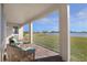 Covered outdoor patio area with comfortable seating and views of the lush backyard and lake at 5550 Sabal Dr, St Cloud, FL 34771