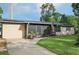 Single-story home featuring a screened porch, solar panels, landscaping, and an American flag displayed outside at 618 Acapulca Way, Altamonte Springs, FL 32714