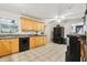 Bright kitchen featuring wooden cabinets, black appliances and neutral tile flooring at 618 Acapulca Way, Altamonte Springs, FL 32714