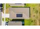 Aerial view of a house roof with solar panels, surrounded by green lawns and neighboring homes at 716 Daring Dr, Davenport, FL 33837