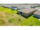 Aerial view showcasing the spacious backyard, lush green lawn, and the home's exterior at 716 Daring Dr, Davenport, FL 33837