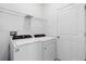 Clean laundry room with washer, dryer, and storage shelving at 716 Daring Dr, Davenport, FL 33837
