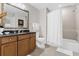 Well-lit bathroom featuring a tub with shower, granite countertops, and a large decorative mirror at 7613 Cabana Ct # 102, Reunion, FL 34747