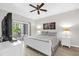 Bright bedroom with wood floors, a ceiling fan, a sliding glass door to a patio, and a white decor at 7613 Cabana Ct # 102, Reunion, FL 34747