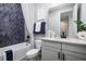 Charming bathroom with blue tile accent wall, tub, vanity with granite counters, and modern fixtures at 842 Creeping Fig St, Apopka, FL 32703
