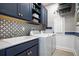 Well-equipped laundry room with modern washer, dryer, stylish tile backsplash and custom cabinets for storage at 842 Creeping Fig St, Apopka, FL 32703