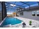 Backyard screened pool with stone deck, waterfall feature and relaxing outdoor seating at 842 Creeping Fig St, Apopka, FL 32703