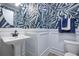 A stylish powder room with blue and white patterned wallpaper, pedestal sink, and modern fixtures at 842 Creeping Fig St, Apopka, FL 32703