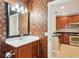 Vanity in bathroom with stainless steel fixtures and view of updated kitchen with stainless appliances at 8430 Leatherleaf Ln, Orlando, FL 32827