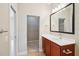 Bathroom with vanity, decorative mirror, and doorway to walk-in closet at 8430 Leatherleaf Ln, Orlando, FL 32827