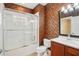 Bathroom featuring a shower with sliding doors, decorative wallpaper, and a wood vanity at 8430 Leatherleaf Ln, Orlando, FL 32827