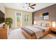 Cozy bedroom with balcony, neutral decor, large windows, and modern furnishings at 8430 Leatherleaf Ln, Orlando, FL 32827