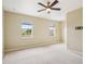 Bright bedroom with neutral walls, ceiling fan and carpet, and two windows at 8430 Leatherleaf Ln, Orlando, FL 32827