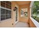 A view of the covered porch, a lantern-style outdoor light fixture, and view of neighborhood at 8430 Leatherleaf Ln, Orlando, FL 32827