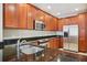 Close up of kitchen with dark granite countertops, stainless steel appliances, and wooden cabinetry at 8430 Leatherleaf Ln, Orlando, FL 32827