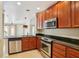 A kitchen with wood cabinets, stainless steel appliances, granite countertops, and tile floors at 8430 Leatherleaf Ln, Orlando, FL 32827
