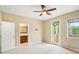 Open main bedroom with neutral walls and carpet, a ceiling fan, ensuite bathroom, and balcony access at 8430 Leatherleaf Ln, Orlando, FL 32827