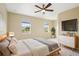 This main bedroom has two windows, tv, ceiling fan, and light neutral walls at 8430 Leatherleaf Ln, Orlando, FL 32827