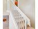 Carpeted staircase with white banister and trim featuring natural light and designer light fixtures at 8430 Leatherleaf Ln, Orlando, FL 32827