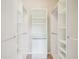 Walk-in closet featuring an adjustable shelving and rod system for storing clothes and accessories at 8430 Leatherleaf Ln, Orlando, FL 32827