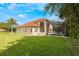 Expansive lawn and exterior view featuring the screened in pool and lanai at 9062 Dancy Tree Ct, Orlando, FL 32836