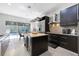 Elegant kitchen with an island, stainless steel appliances, dark cabinetry, and a view of the pool at 9062 Dancy Tree Ct, Orlando, FL 32836