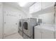Laundry room with stainless steel appliances, white cabinets, sink and mirror at 9062 Dancy Tree Ct, Orlando, FL 32836