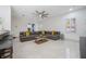 Comfortable living room with a large sectional sofa, modern ceiling fan, and stone floors at 9062 Dancy Tree Ct, Orlando, FL 32836