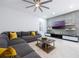 Cozy living room with a large sectional sofa, decorative stone accent wall, and modern entertainment center at 9062 Dancy Tree Ct, Orlando, FL 32836