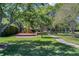 Playground with a colorful structure, slides, and a walkway amidst lush greenery at 9062 Dancy Tree Ct, Orlando, FL 32836