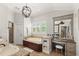Bathroom with a soaking tub under windows, vanity and make up table with stool at 9146 Bay Point Dr, Orlando, FL 32819
