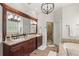 Beautiful bathroom featuring dual sinks, granite countertops, a walk-in shower, and soaking tub at 9146 Bay Point Dr, Orlando, FL 32819