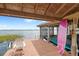 Covered boat dock featuring wood floors, boat lift, lake access and a pink surfboard for watersport enthusiasts at 9146 Bay Point Dr, Orlando, FL 32819