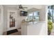 Outdoor kitchen featuring granite countertops, a TV, and a picturesque lake view at 9146 Bay Point Dr, Orlando, FL 32819