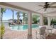 Covered patio with brick flooring overlooks the pool and the lake at 9146 Bay Point Dr, Orlando, FL 32819