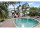 Waterfront house featuring a pool with a pool deck overlooking a lake and dock at 9146 Bay Point Dr, Orlando, FL 32819