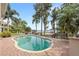 Inviting kidney-shaped pool with brick patio and serene lake views surrounded by lush landscaping at 9146 Bay Point Dr, Orlando, FL 32819