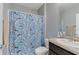 Bathroom features a shower with a whimsical shark-themed curtain and granite sink at 984 Chanler Dr, Haines City, FL 33844