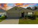 Charming single Gathering home with a two-car garage, lawn, and attractive landscaping at 984 Chanler Dr, Haines City, FL 33844