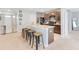 Kitchen features an island with seating and dark brown cabinets, appliances and carpeted flooring in an open concept layout at 984 Chanler Dr, Haines City, FL 33844