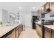 Open kitchen with dark cabinets, stainless steel appliances, and an archway to the dining area at 984 Chanler Dr, Haines City, FL 33844