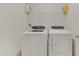 A bright laundry room showcases a modern washer and dryer, with overhead shelving for storage at 984 Chanler Dr, Haines City, FL 33844
