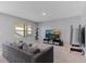 Cozy living room features a comfortable sofa, a large window with natural light, and a modern entertainment center at 984 Chanler Dr, Haines City, FL 33844