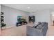 Living area featuring a comfortable sofa, natural light from the window, and entertainment center at 984 Chanler Dr, Haines City, FL 33844
