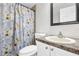 Bathroom boasts a floral shower curtain, vanity with granite countertop, and a framed mirror at 9900 Sweepstakes Ln # 1, Orlando, FL 32837