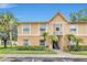 Charming condo exterior with tan walls, palm trees and manicured landscaping, and a blue sky at 9900 Sweepstakes Ln # 1, Orlando, FL 32837
