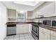 Practical kitchen with white cabinets, stainless steel appliances, tiled floors, and ample counter space at 9900 Sweepstakes Ln # 1, Orlando, FL 32837