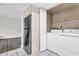 Convenient laundry room with washer, dryer, storage shelves, and a modern refrigerator at 9900 Sweepstakes Ln # 1, Orlando, FL 32837