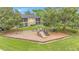 Community playground with swings, slide, and climbing structure surrounded by lush green grass and mature trees at 9900 Sweepstakes Ln # 1, Orlando, FL 32837